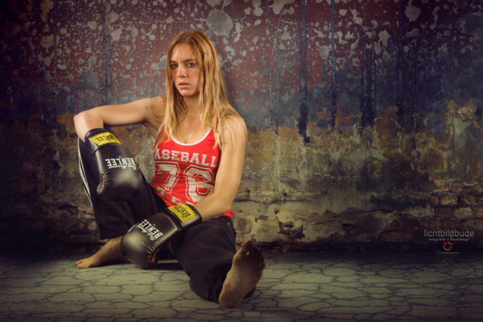 Nadien Petry nach dem Sport mit Boxhandschuhen am Boden sitzend