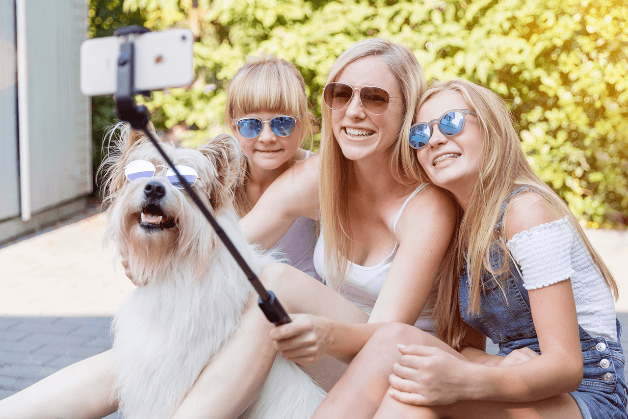 Nadine Petry macht mit zwei Kindern und einem Hund ein Selfie mit einem Selfiestick